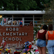 A general view as people mourn outside a memorial to honor the victims killed in last month’s school shooting outside Robb Elementary School in Uvalde, Texas.